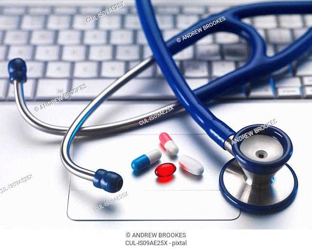 Stethoscope and medicine on laptop computer, still life
