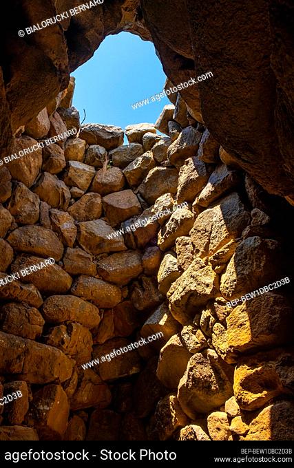 Arzachena, Sardinia / Italy - 2019/07/19: Archeological ruins of Nuragic complex La Prisgiona - Nuraghe La Prisgiona - with interior of stone tower of Neolithic...