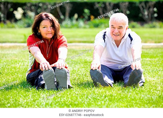 Elderly Senior Couple Doing Stretching Exercise In Park