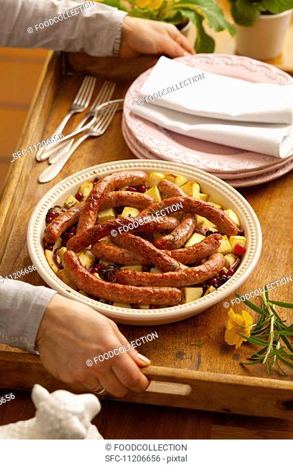 Sausages on fried potatoes with cranberries