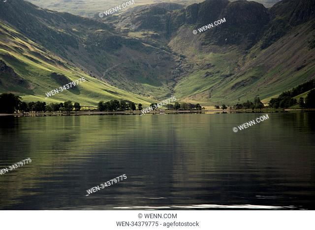 Its a beautiful morning in the Lake District, Boats sail on Windermere and the stunning mountains reflect on Lake Buttermere