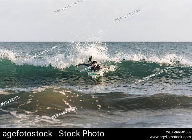 Carefree woman surfing in sea, Gran Canaria, Canary Islands