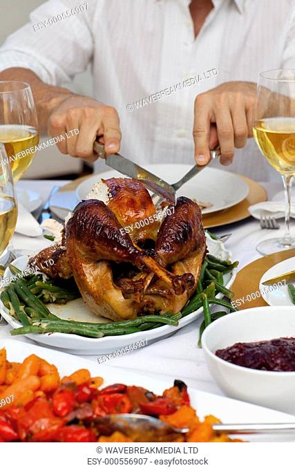 Close-up of a man cutting a turkey for Christmas dinner at home