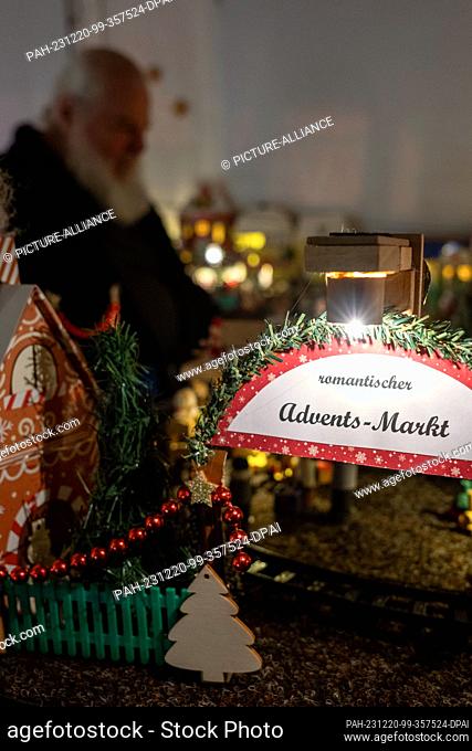 PRODUCTION - 05 December 2023, Bavaria, Coburg: Horst Gründel sits in the middle of his miniature Christmas market measuring around eight square meters