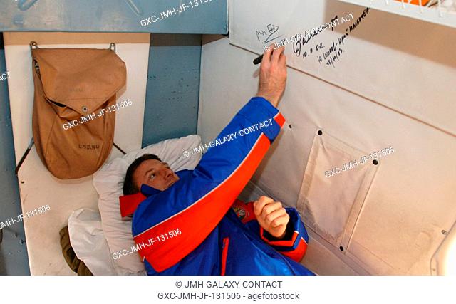 Astronaut C. Michael Foale, Expedition 8 commander and NASA ISS science officer, signs the inside of the Russian search and rescue helicopter as is tradition...