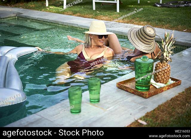 two mature friends enjoying an afternoon at the pool