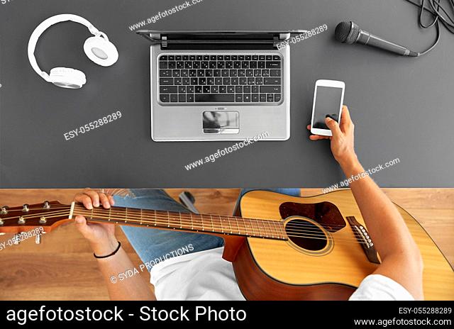 young man with guitar and smartphone at table