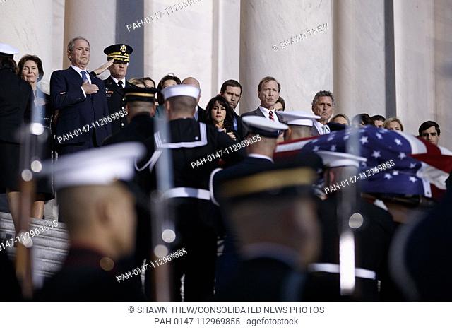 Former US President George W Bush, former First Lady Laura Bush and members of the Bush family look on as a joint service members of a military casket team...