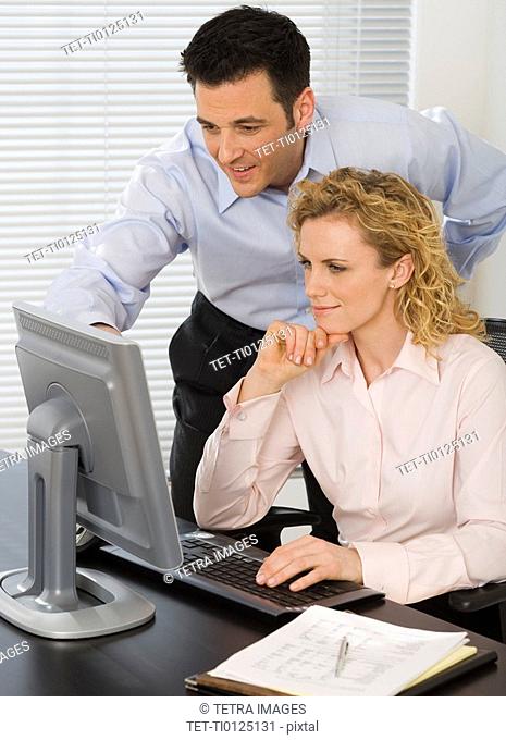 Businesspeople looking at computer