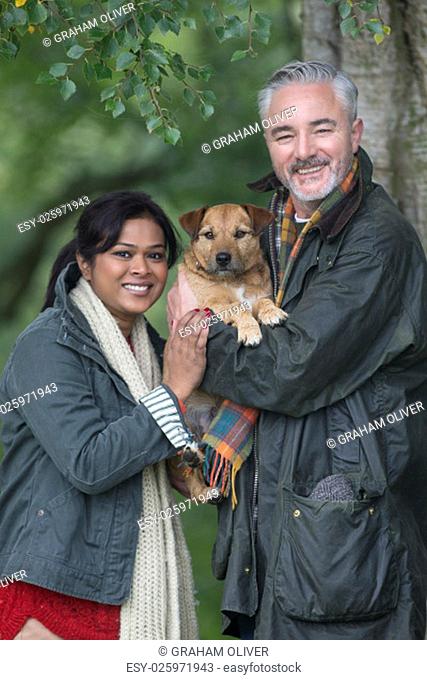 Portrait of a couple with their dog whilst out on a walk