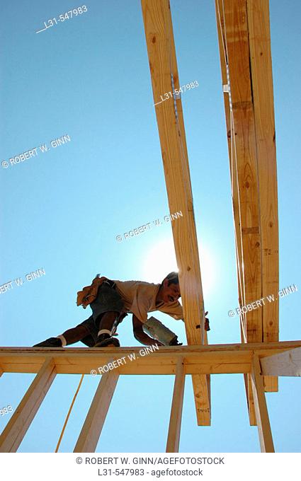 Latin work crew building wooden stick built house home cutting measure nailing on hot day