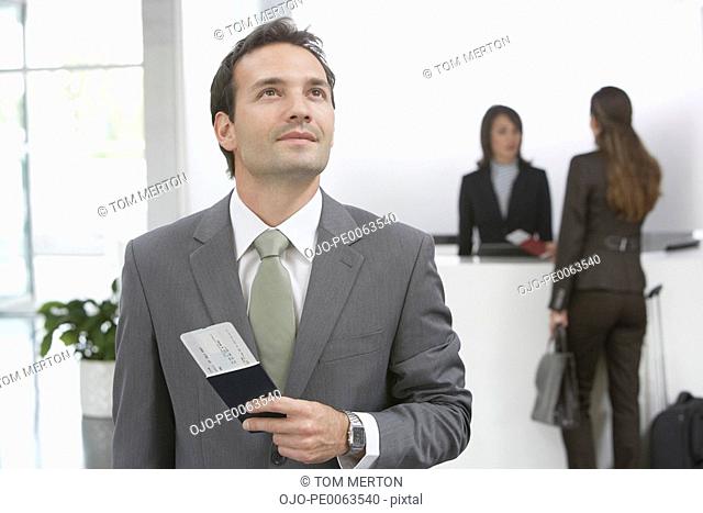Businessman holding passport and airline ticket