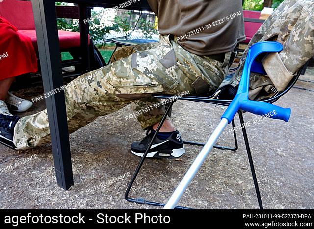 PRODUCTION - 29 September 2023, Ukraine, Kiew: A wounded Ukrainian soldier put down his crutch during an exit from the hospital