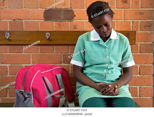 Schoolgirl sits alone outside her classroom, KwaZulu Natal Province, South Africa