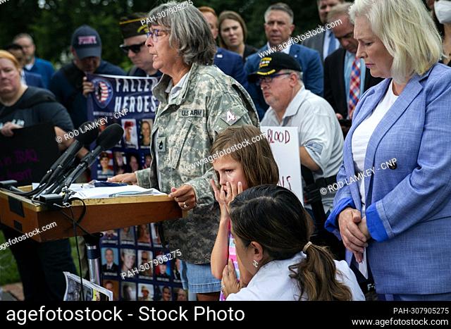 Brielle Robinson, 9, wipes tears from her face as she listens to her grandmother Susan Zeier offer remarks about her father