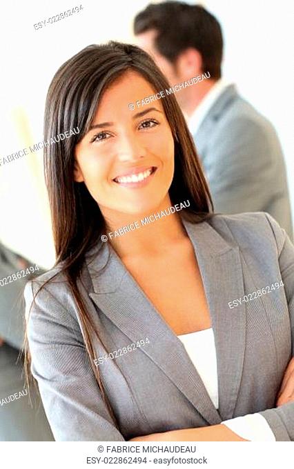Portrait of beautiful businesswoman standing in front of group