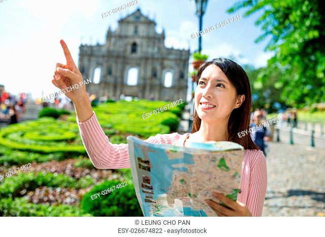 Woman holding city map and finger pointing the location