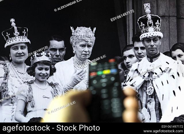 Belgrade, Serbia - September 12, 2022: Watching King George VI coronation at Westminster Abbey, London, on 12 May 1937 documentary on tv with remote controle in...