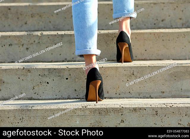 Back view close up of a woman legs wearing high heels walking up stairs