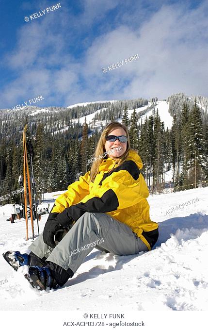 A young women rests after a run at Sun Peaks Ski Resort just North of Kamloops, British Columbia, Canada