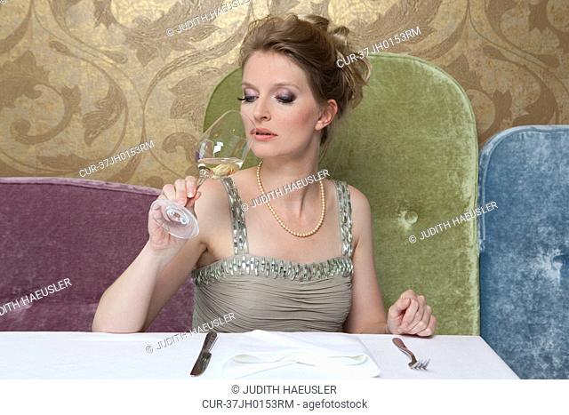 Woman in evening gown drinking wine