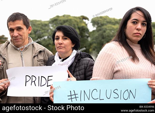 A group of people holding inclusión and pride signs as a protest. LGBT Concept