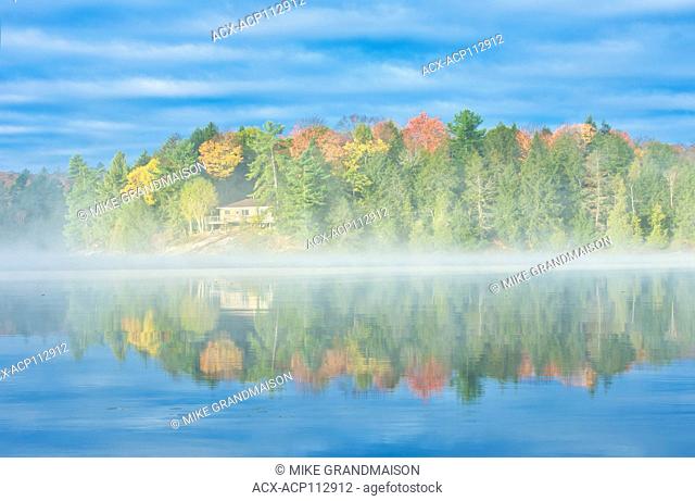 Fog on Horseshoe Lake in autumn with cottage , Near Parry Sound, Ontario, Canada