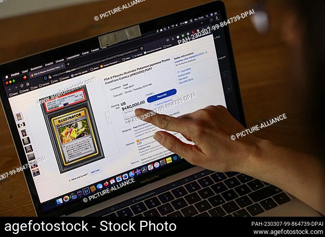 06 March 2023, Berlin: A woman points to the price on her laptop at an eBay auction. For 480, 000 dollars, the card Japanese ""Pikachu Illustrator"" from the...