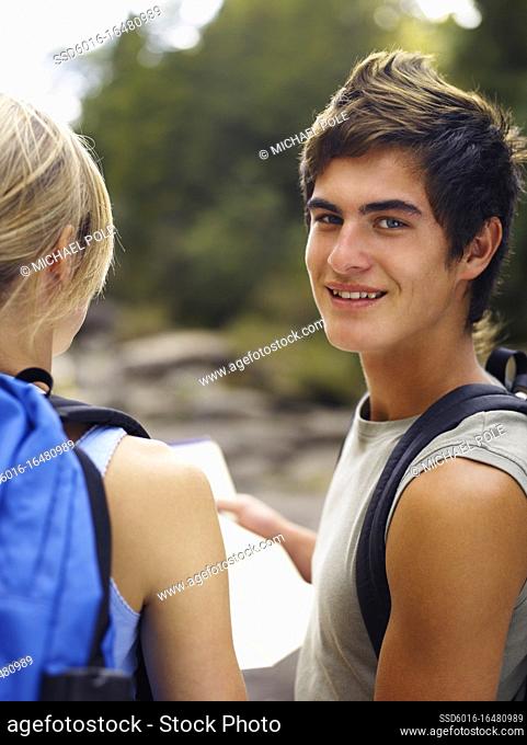 Young couple looking at directions on a tramp through the wilderness