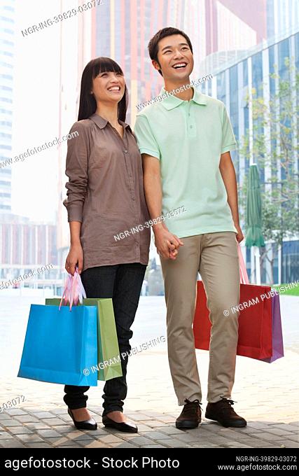Young couple walking with shopping bags in hands, Beijing, China