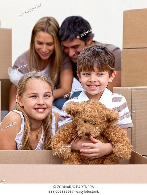 Little boy and girl moving house with parents