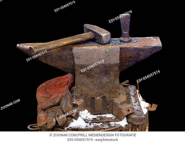 old used anvil and hammer in black back