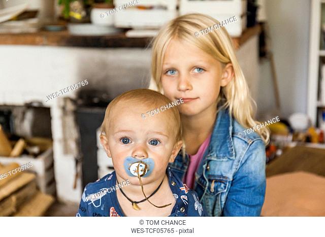 Portrait of girl with baby boy brother at home