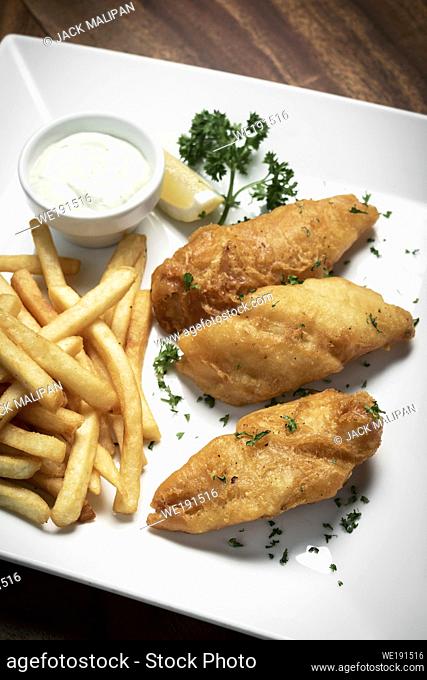british traditional fish and chips meal on classic wood table