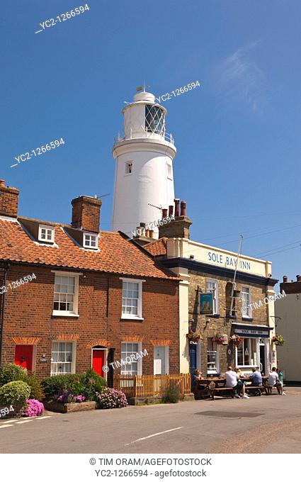 The Sole Bay Inn pub with people sitting outside and lighthouse behind in Southwold , Suffolk , England , Great Britain , Uk