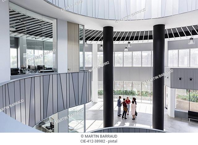 Business people talking in architectural, modern office atrium