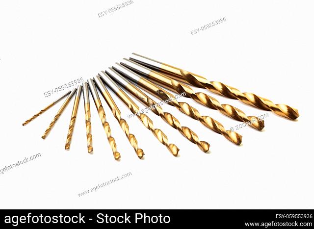 A set of ten drill bits on white with selective focus