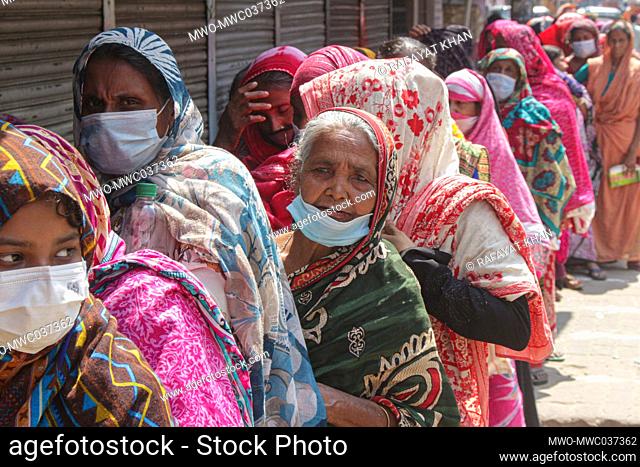 Women are gathering in a queue to buy Rice and Flour from the open market sale (OMS) in Modu Shohid, Sylhet. A nationwide lockdown has been imposed for 7 days