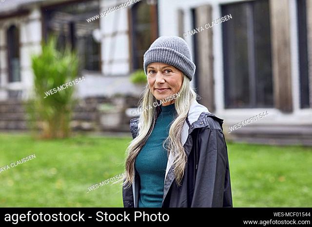 Confident mature woman wearing knit hat in back yard
