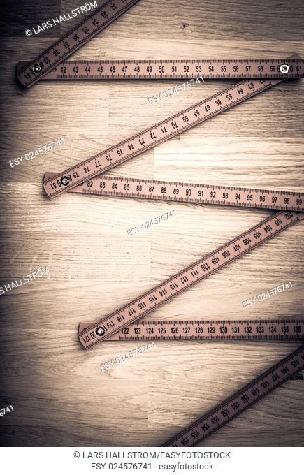 Folding rule on wooden table. Concept image of measurement, construction and work tool