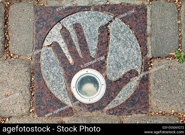 Paving flagstone with open hand in Uzupis, art district in Vilnius, Lithuania