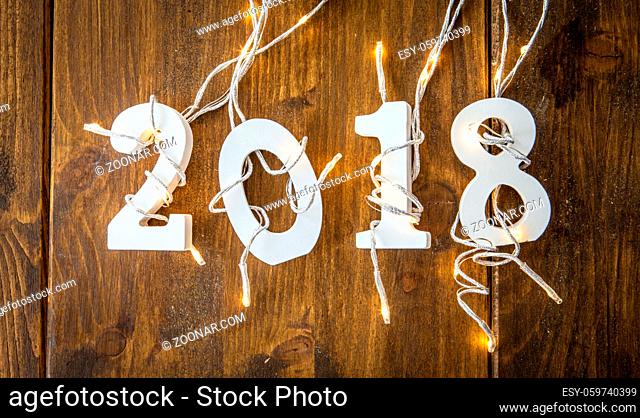 2018 mit Lichterkette auf rustikalem Hintergrund aus Holz
