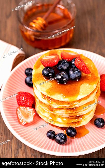 Pancakes with fresh strawberries, blueberries and syrup