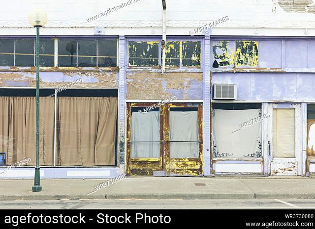 Main Street in a town, abandoned shopfronts, with boarded up windows, closed business