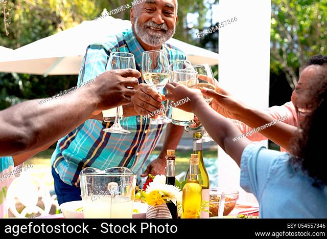 Senior African American couple and their family sitting by a table in the garden