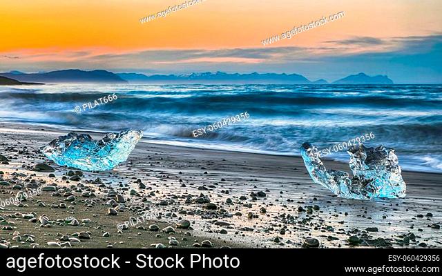 Incredible pieces of the iceberg sparkle on famous Diamond Beach at Jokulsarlon lagoon during sunset. Location: Jokulsarlon lagoon, Diamond beach
