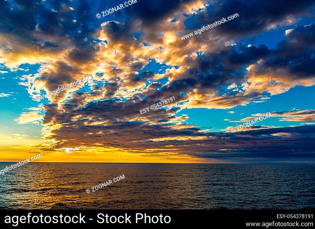 Beautiful sunset at the beach, amazing colors, light beam shining through the cloudscape over the arabian gulf seascape, united arab emirates
