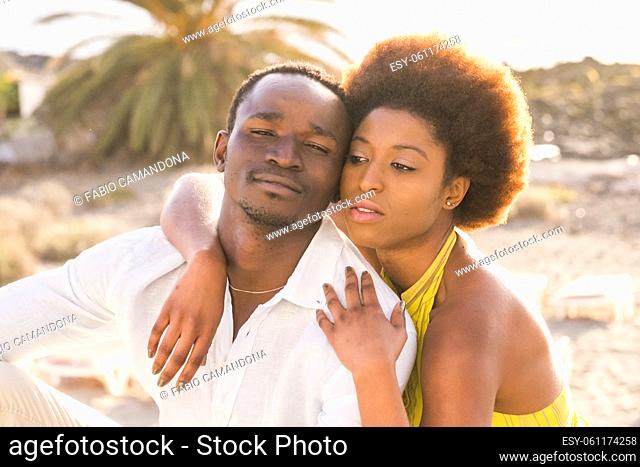 Pretty young black boy and girl couple enjoy outdoor leisure together hugging and loving in friendship or relationship. Happy adult man and woman smile