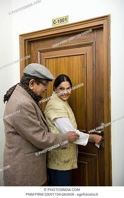 Couple unlocking the door of a house