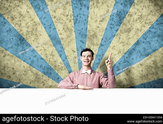 Young funny guy in checked shirt with banner pointing with finger up